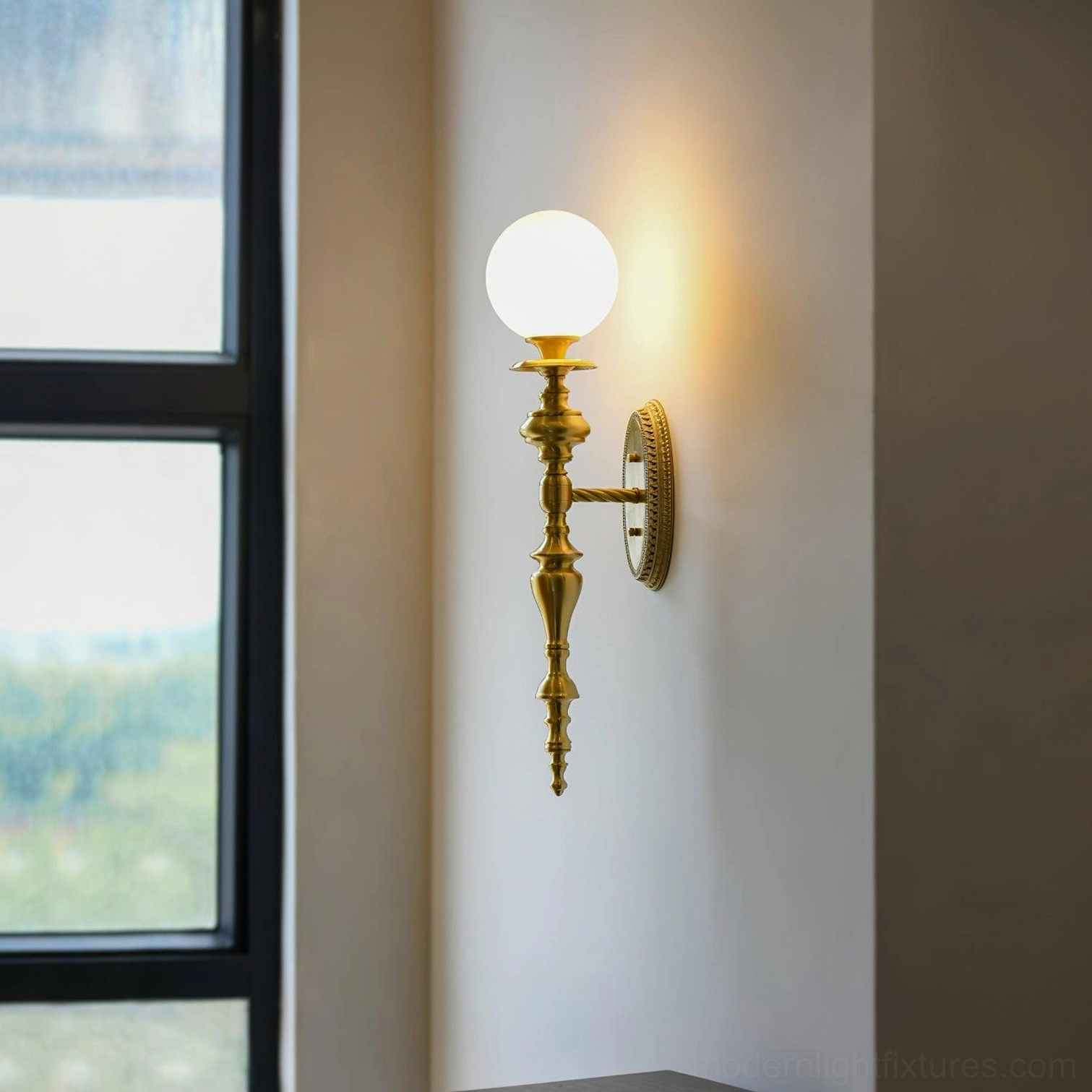 Brass wall sconce mounted by residential window showing frosted glass shade and classic retro style