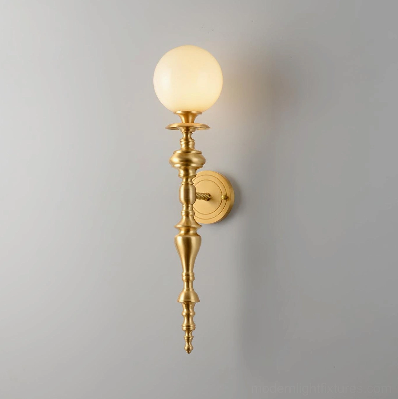 Model A brass wall sconce with frosted glass shade in luxury home lighting installation