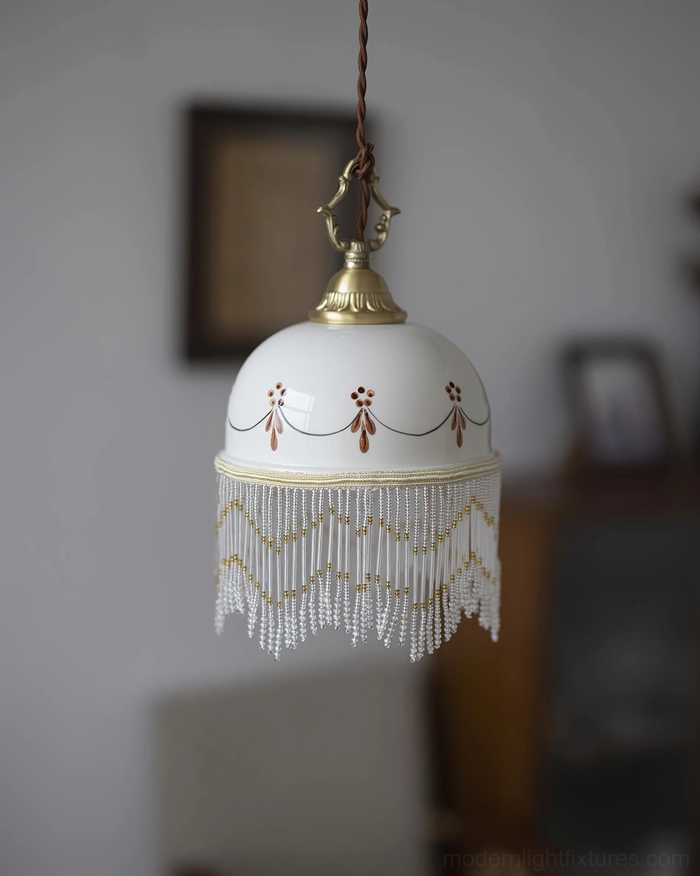 Vintage-inspired Beaudine pendant lamp with white ceramic shade, gold trim, red ornamental patterns, beaded fringe