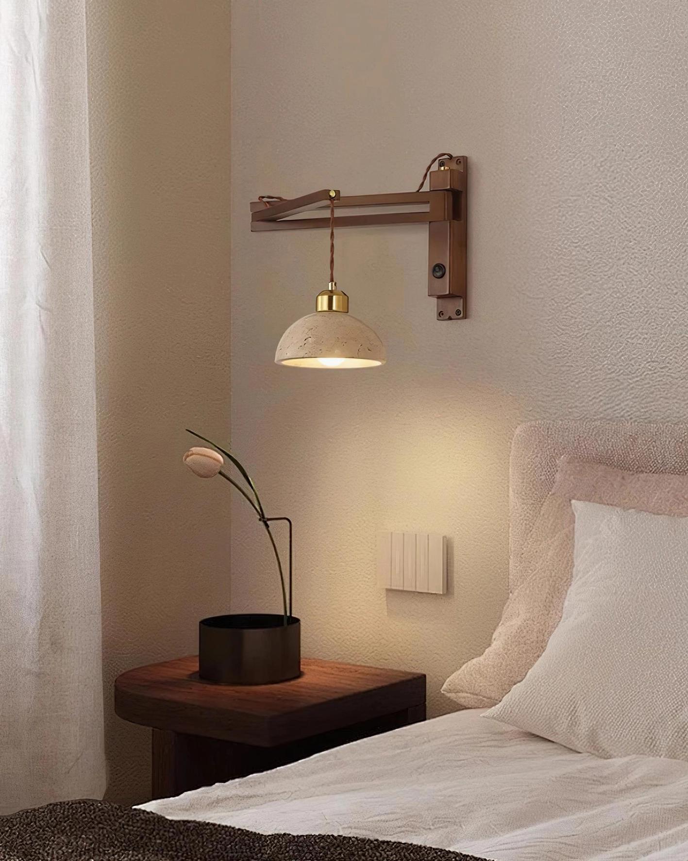 Swing arm wall sconce installation on bedroom accent wall, warm mood lighting from adjustable travertine shade lamp