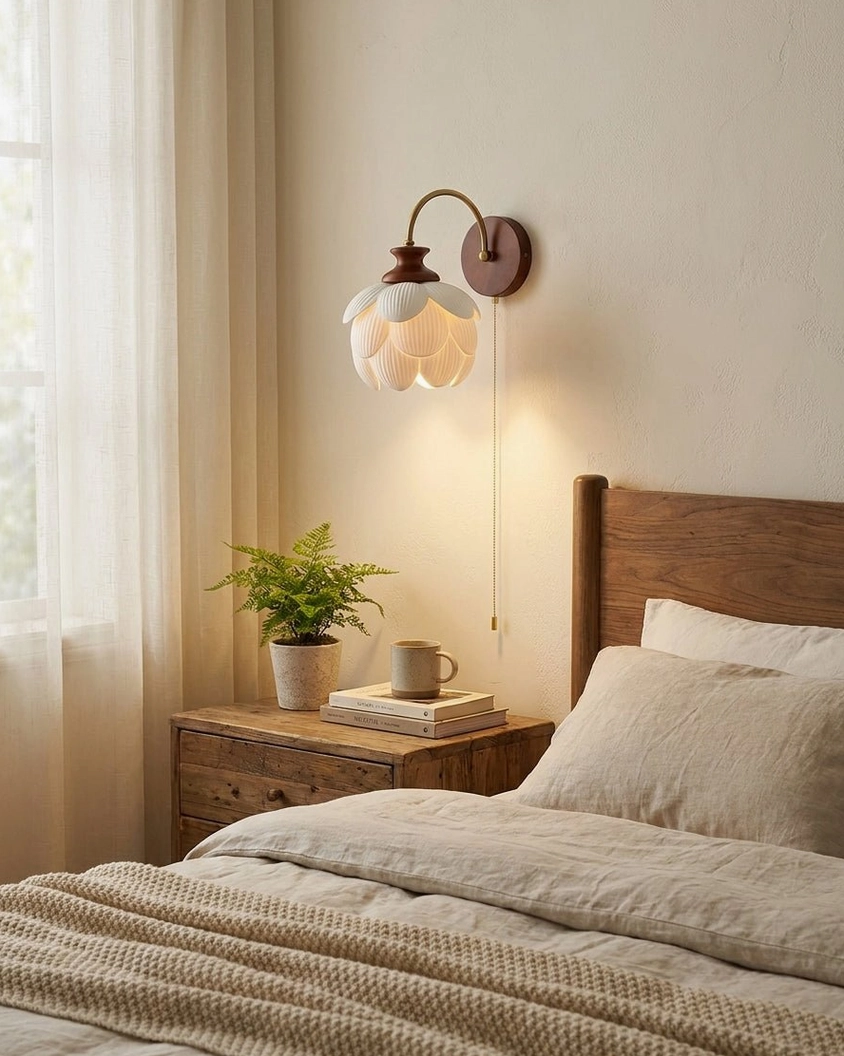 Camiora ceramic wall sconce installed in bedroom corner above nightstand with linen bedding creating warm farmhouse ambiance