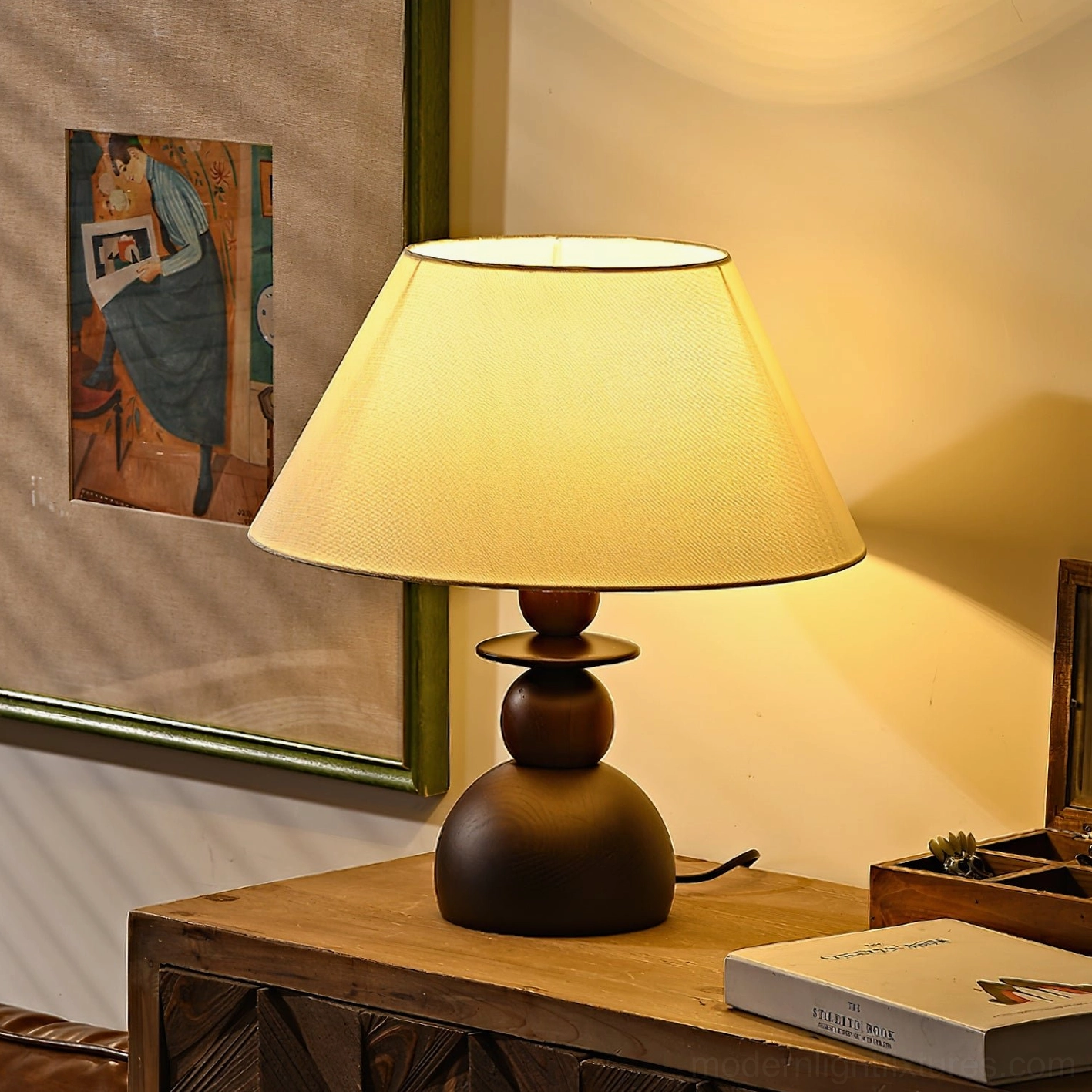 Modern table lamp with walnut base and cream fabric shade displayed on bedroom dresser with wall art