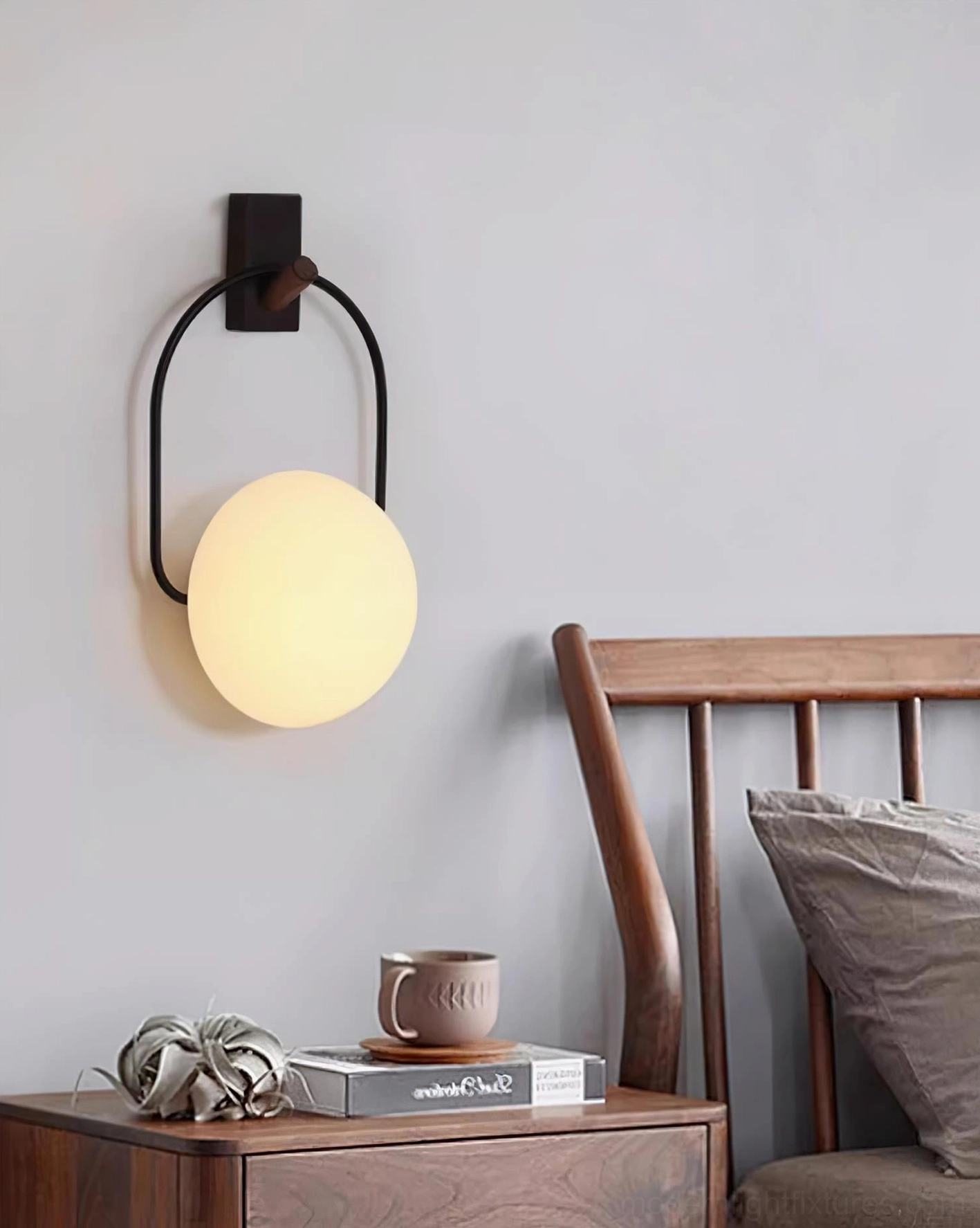 Bedroom wall sconce light fixture, cozy bedroom interior lighting, black metal wall bracket spherical frosted shade