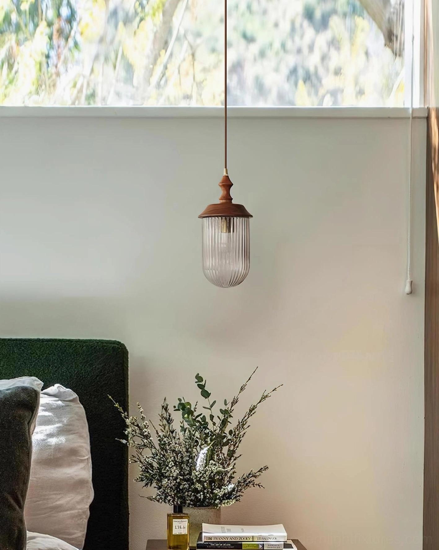 Bedside pendant lamp with clear ribbed glass and walnut wood top hanging beside bed with neutral accent wall