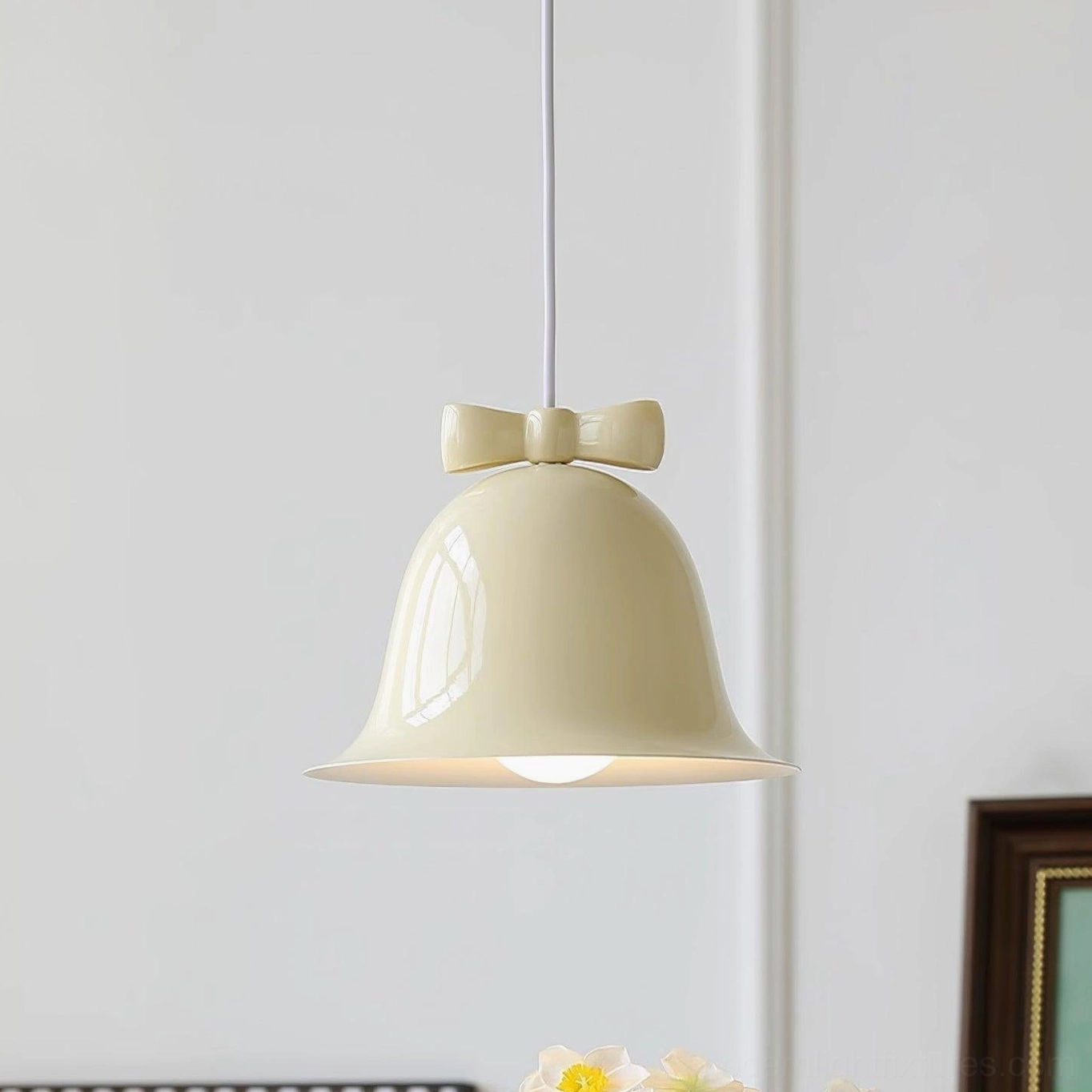 Beige ceramic bell-shaped pendant light with brown bow in neutral studio lighting
