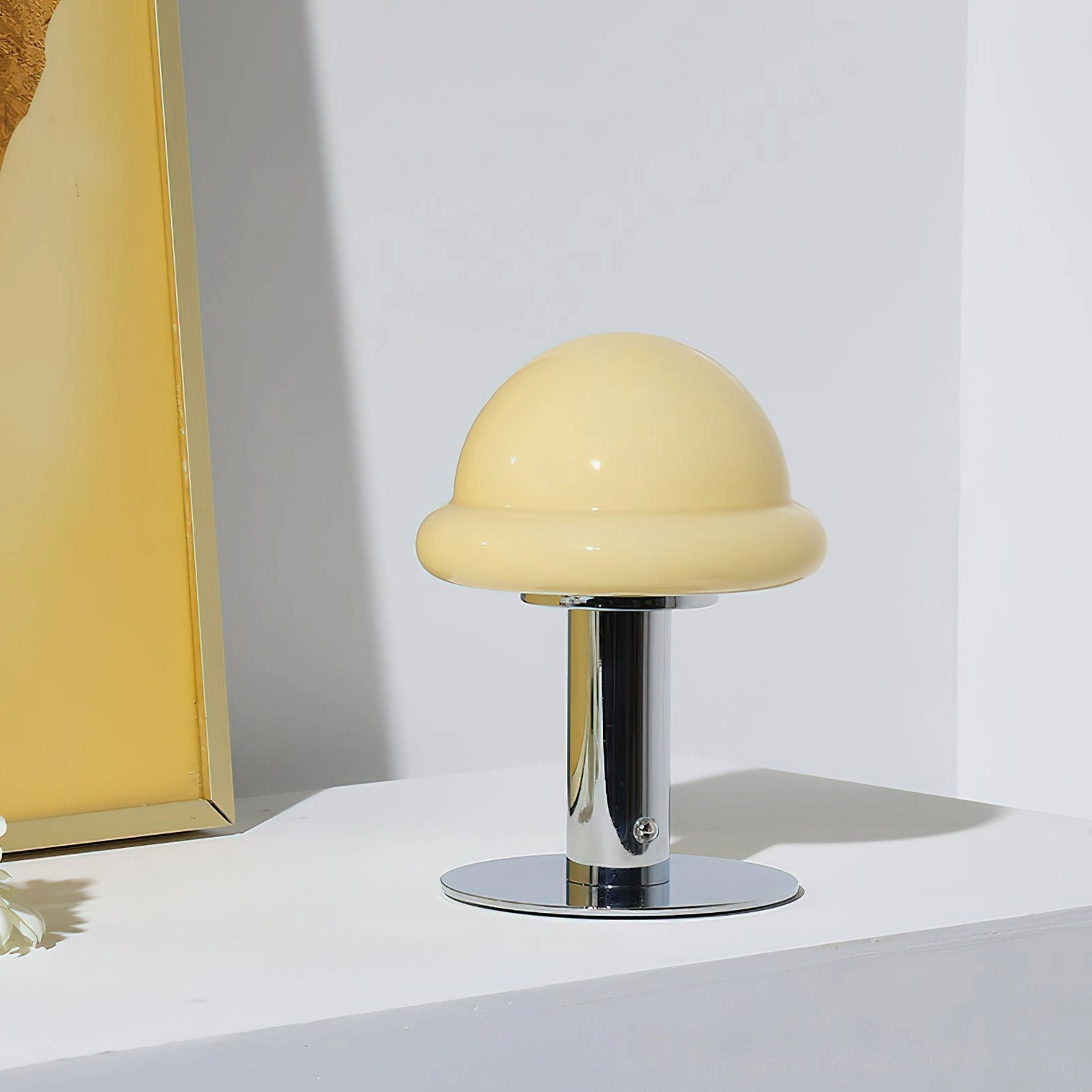 Cream beige soft glossy mushroom cordless lamp with polished chrome metal pole and base on minimalist white shelf