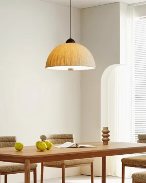 Beige Doria pendant light hanging above dining table in residential dining room, warm ambient lighting