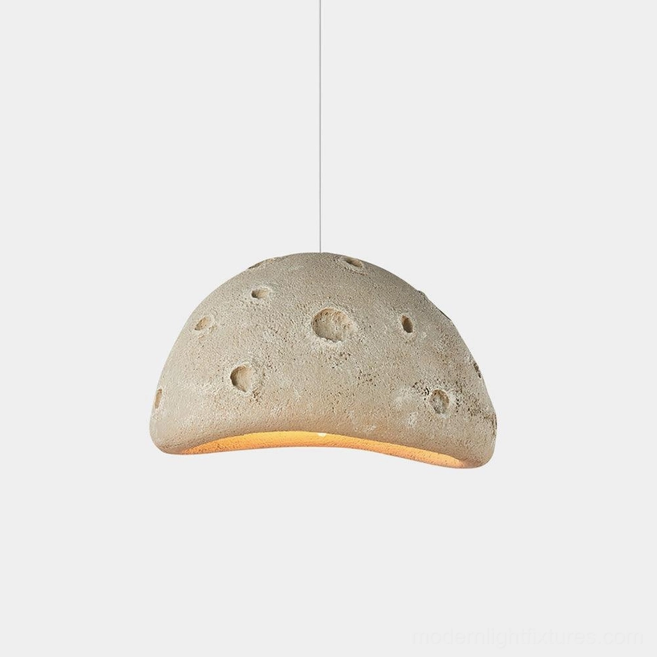 Meteorite crater pendant light in beige with textured dome surface and warm underglow, front low-angle view on white background