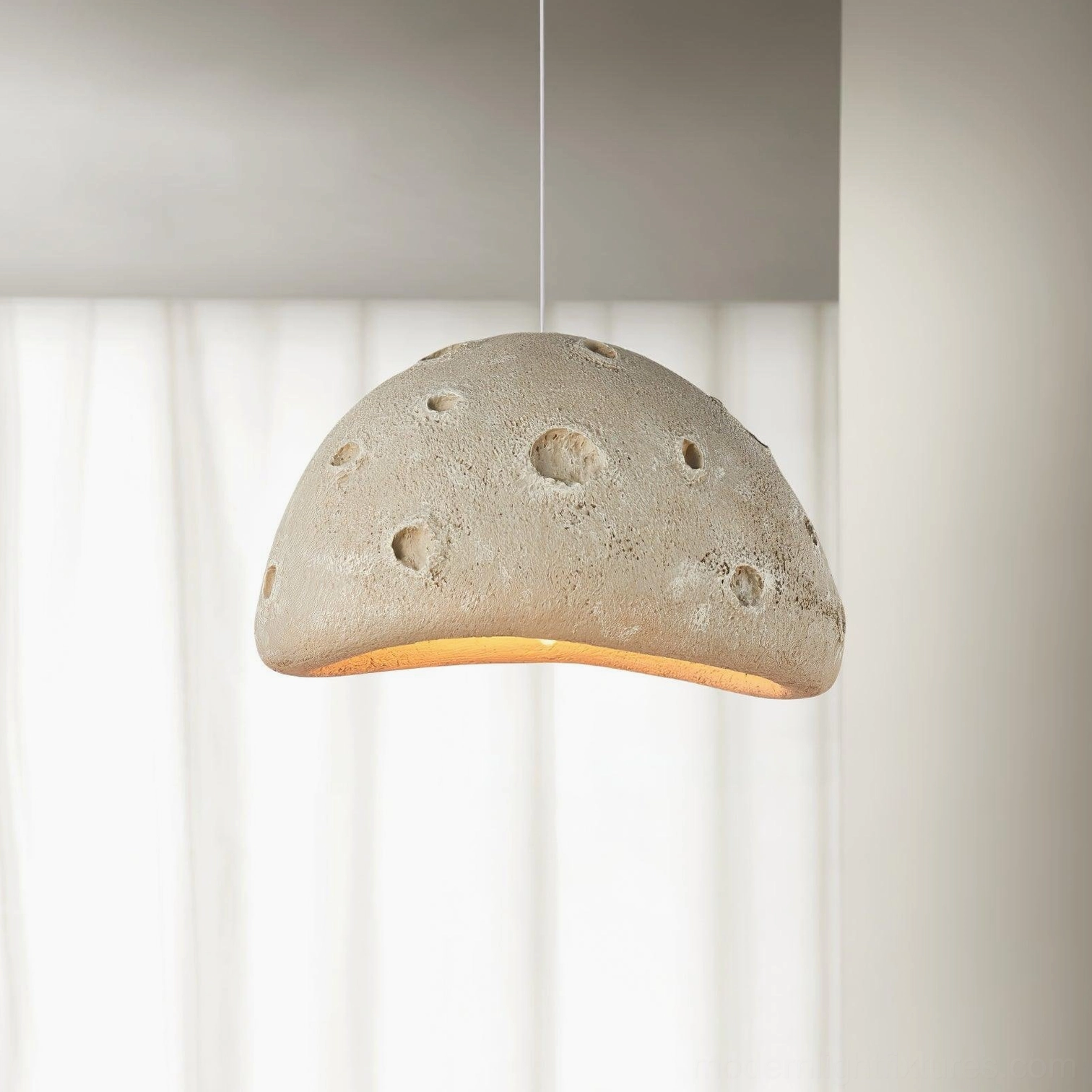 Beige meteorite crater pendant light in minimalist home space with sheer curtains and warm under-lighting