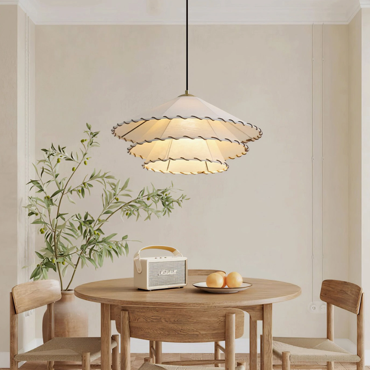 Beige ruffled pendant fixture with soft diffused lighting above wooden dining furniture in warm home setting