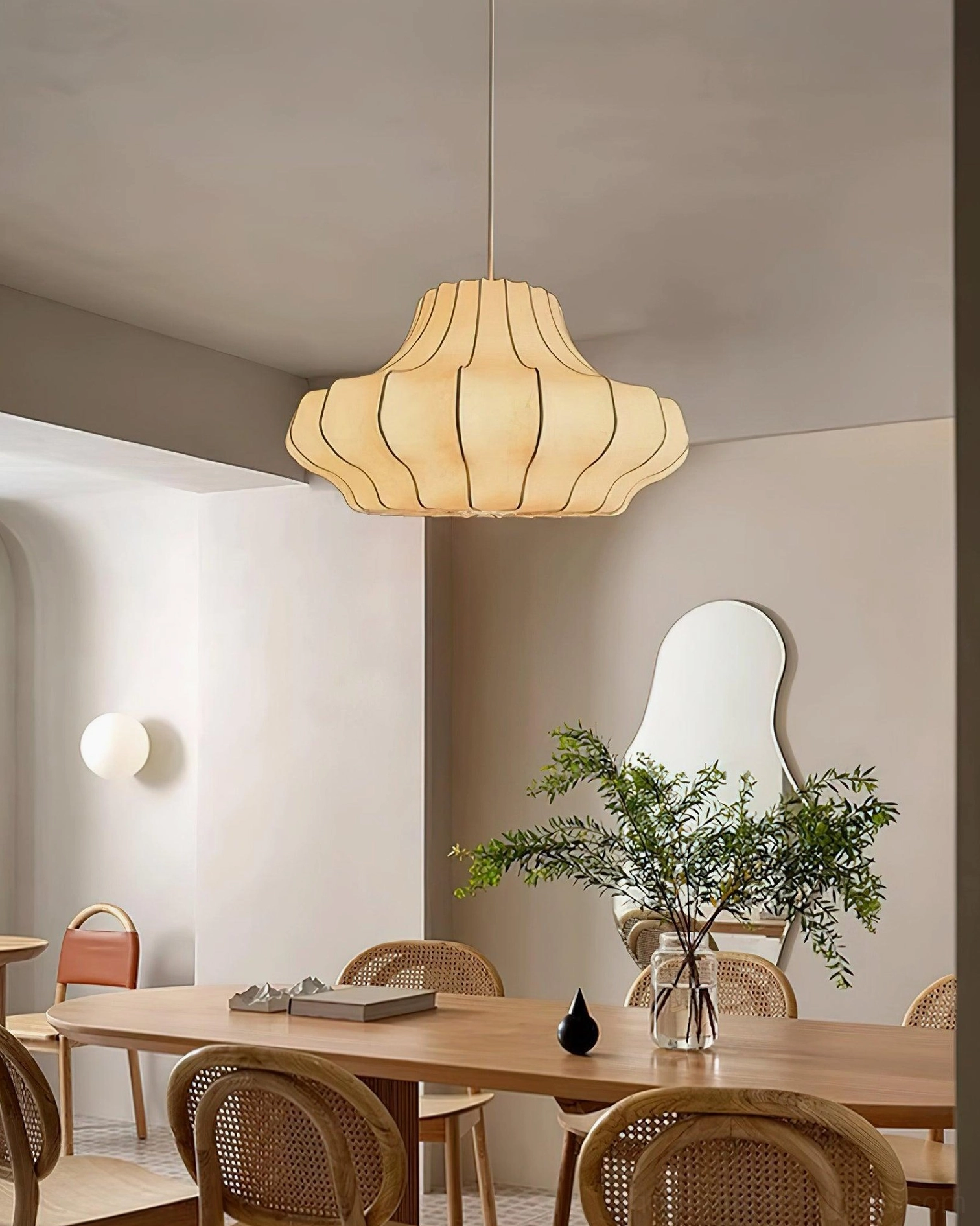 Warm beige pleated pendant lamp with ambient lighting above modern dining room table