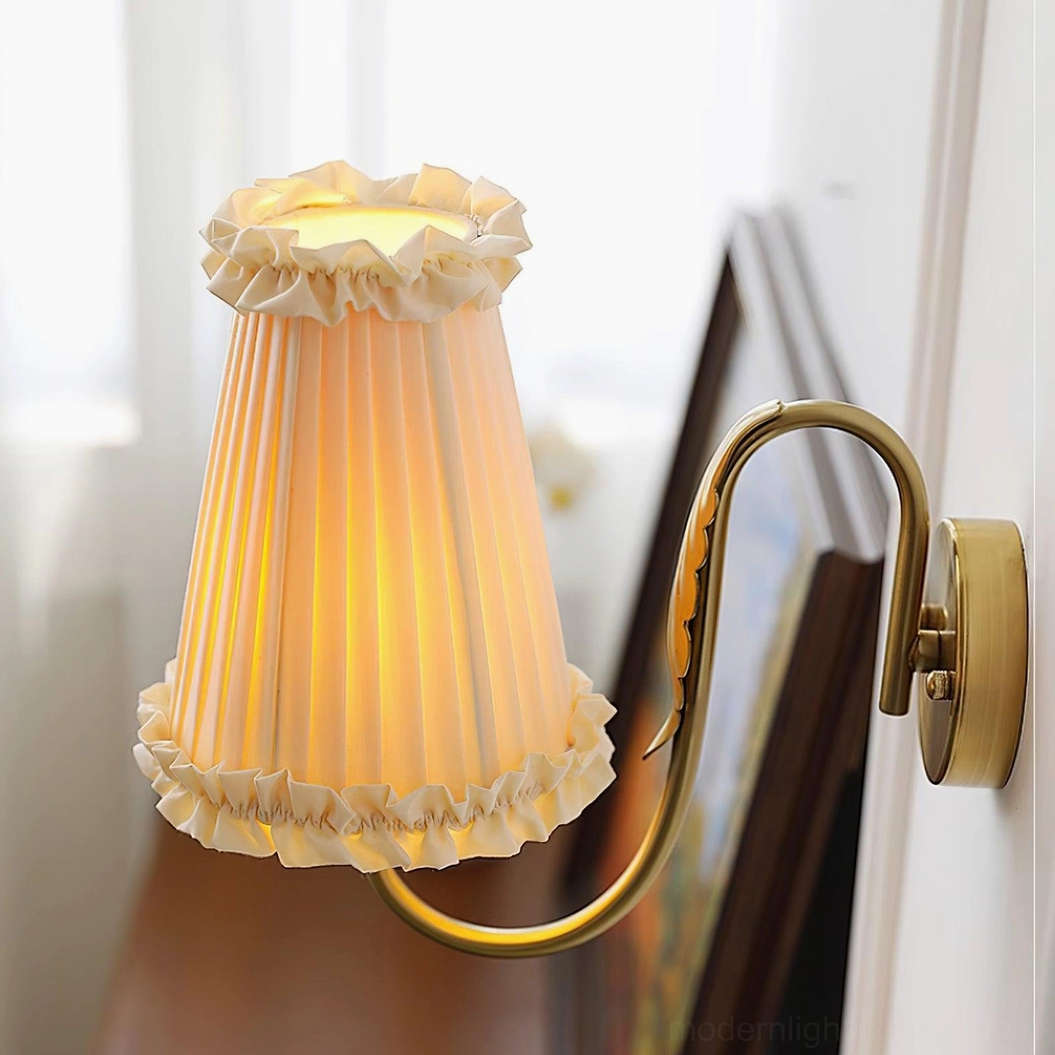 Beige pleated fabric shade of brass wall sconce with lighting effect