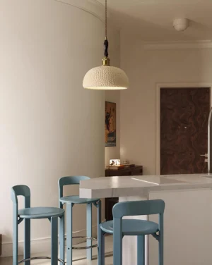 Beige textured resin pendant light hanging in modern kitchen above counter, Scandinavian interior design