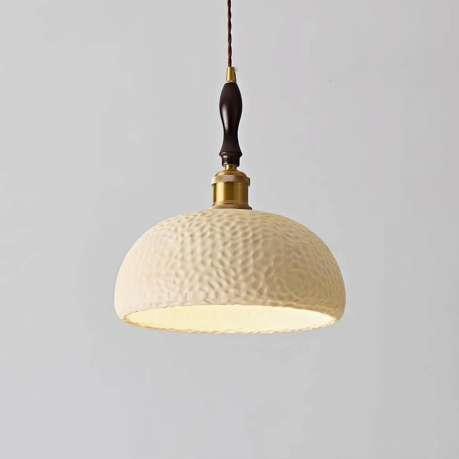 Beige textured resin pendant lamp with warm metal and wood accents, decorative studio photography