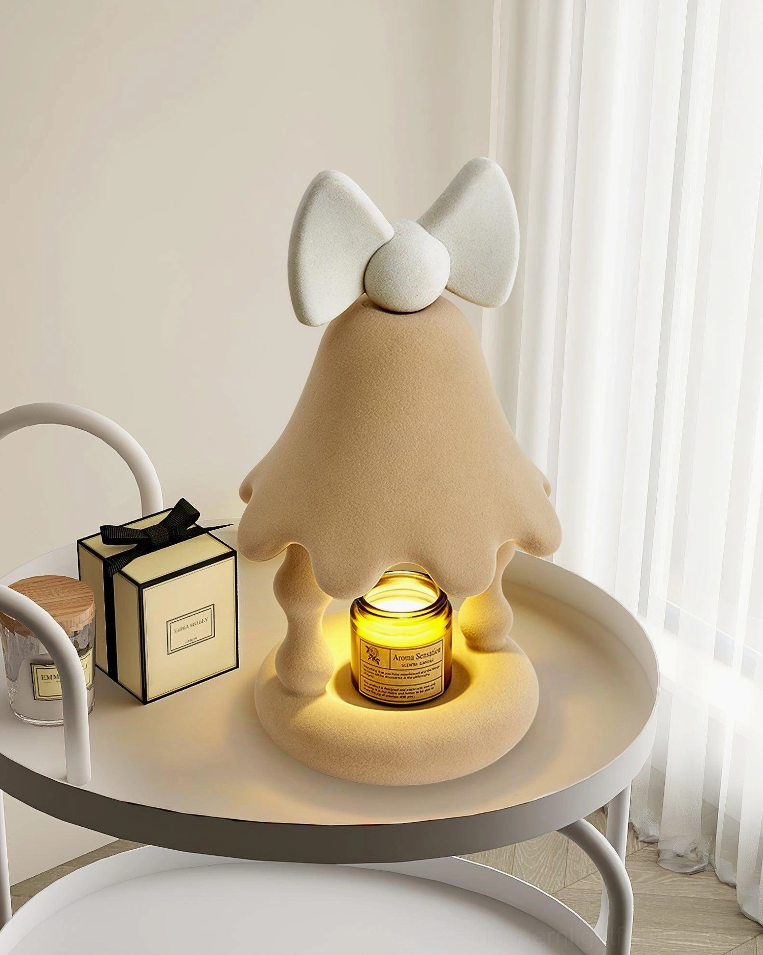 Beige Stacy candle warmer lamp placed on bedroom side table with gift boxes nearby, cozy home interior scene with glowing candle