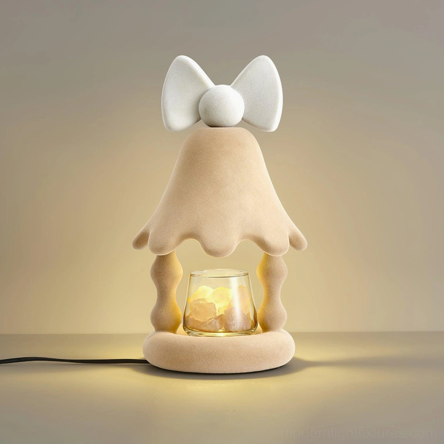 Beige Stacy candle warmer lamp three-quarter view showcasing flocked velvet material, wavy lantern silhouette, and bow top detail