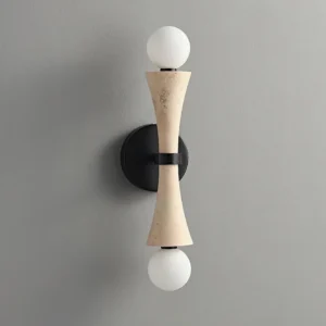Beige travertine wall sconce with frosted glass globes mounted on gray wall, minimalist interior lighting design
