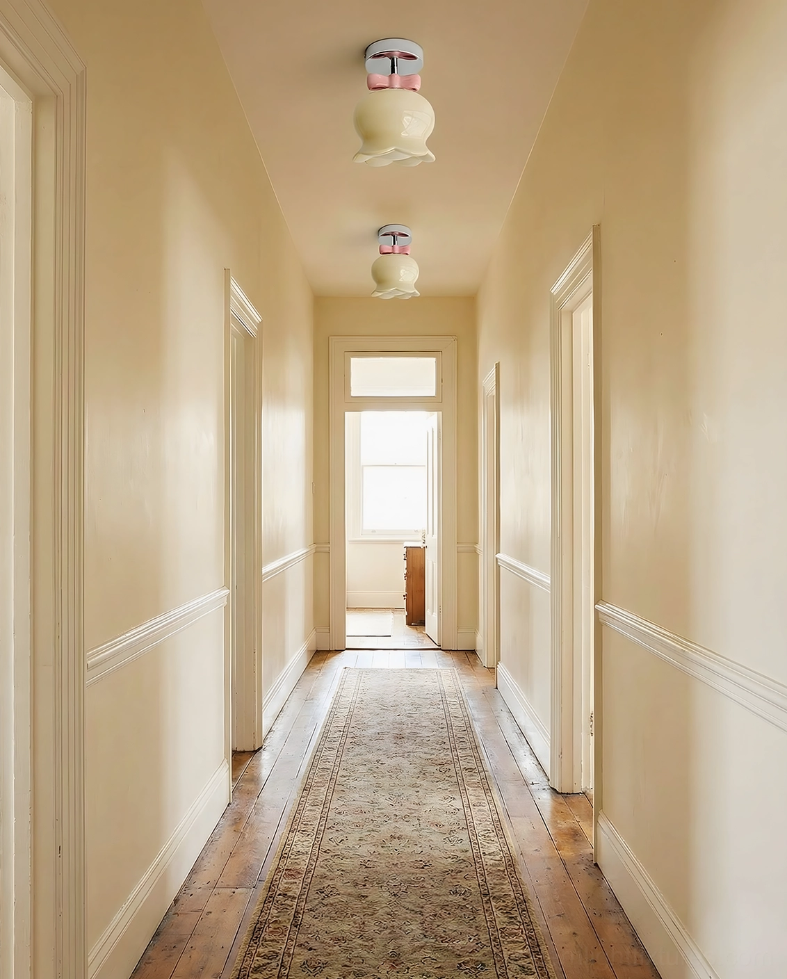 Multiple bell ceiling light fixtures with mixed pink and cream shades installed in yellow-walled residential hallway corridor, cohesive cozy home decor