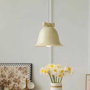 Beige bell pendant lamp hanging in warm Nordic interior with floral wall decor and wooden furniture