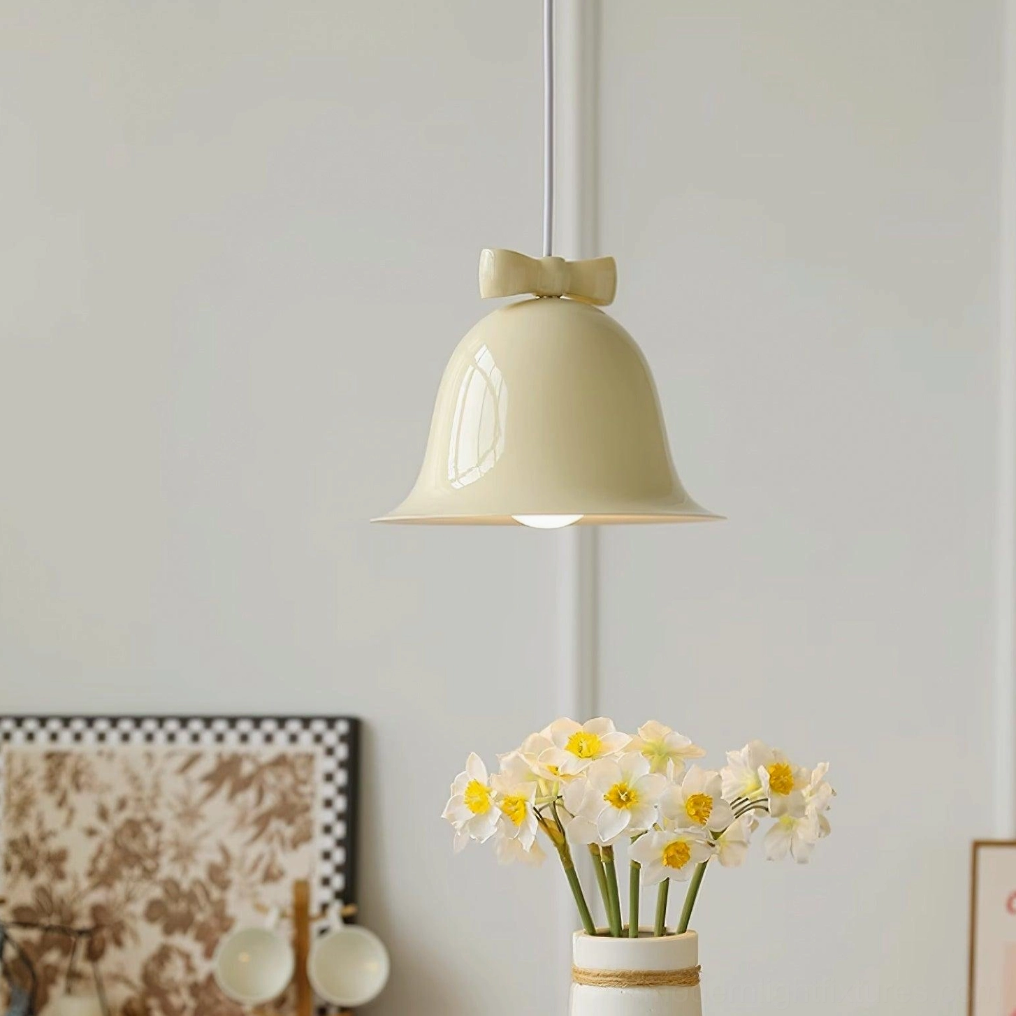Beige bell pendant lamp hanging in warm Nordic interior with floral wall decor and wooden furniture