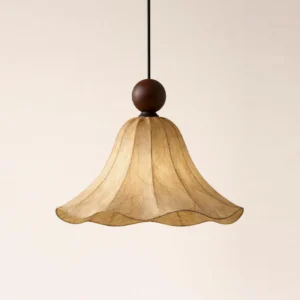 Close-up low-angle view of rice-paper bell pendant light showing textured scalloped rim, paper fiber detail, and turned wood ball finial
