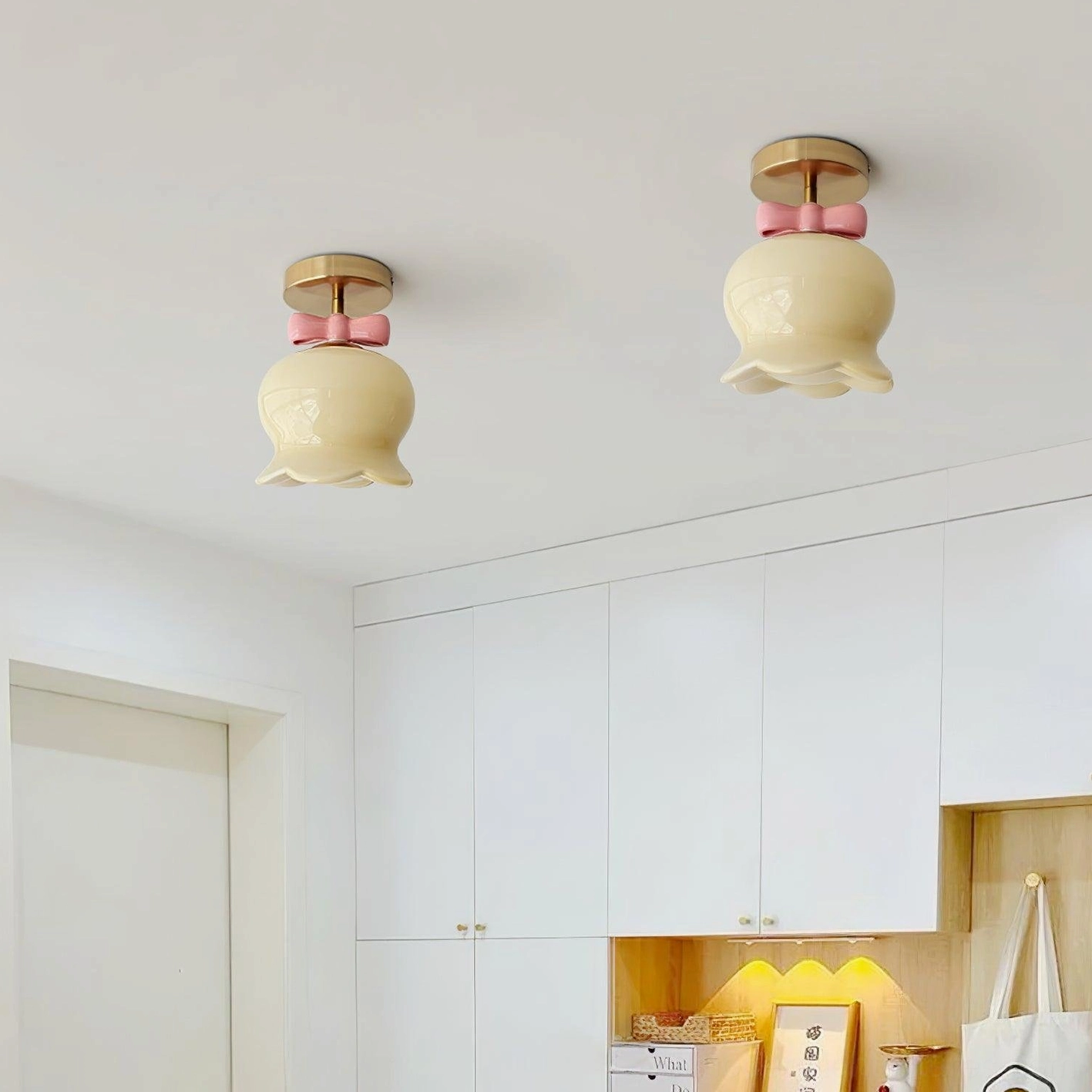 Full view of bell-shaped ceiling light fixture demonstrating curved bell form and decorative bow knot detailing in studio setting