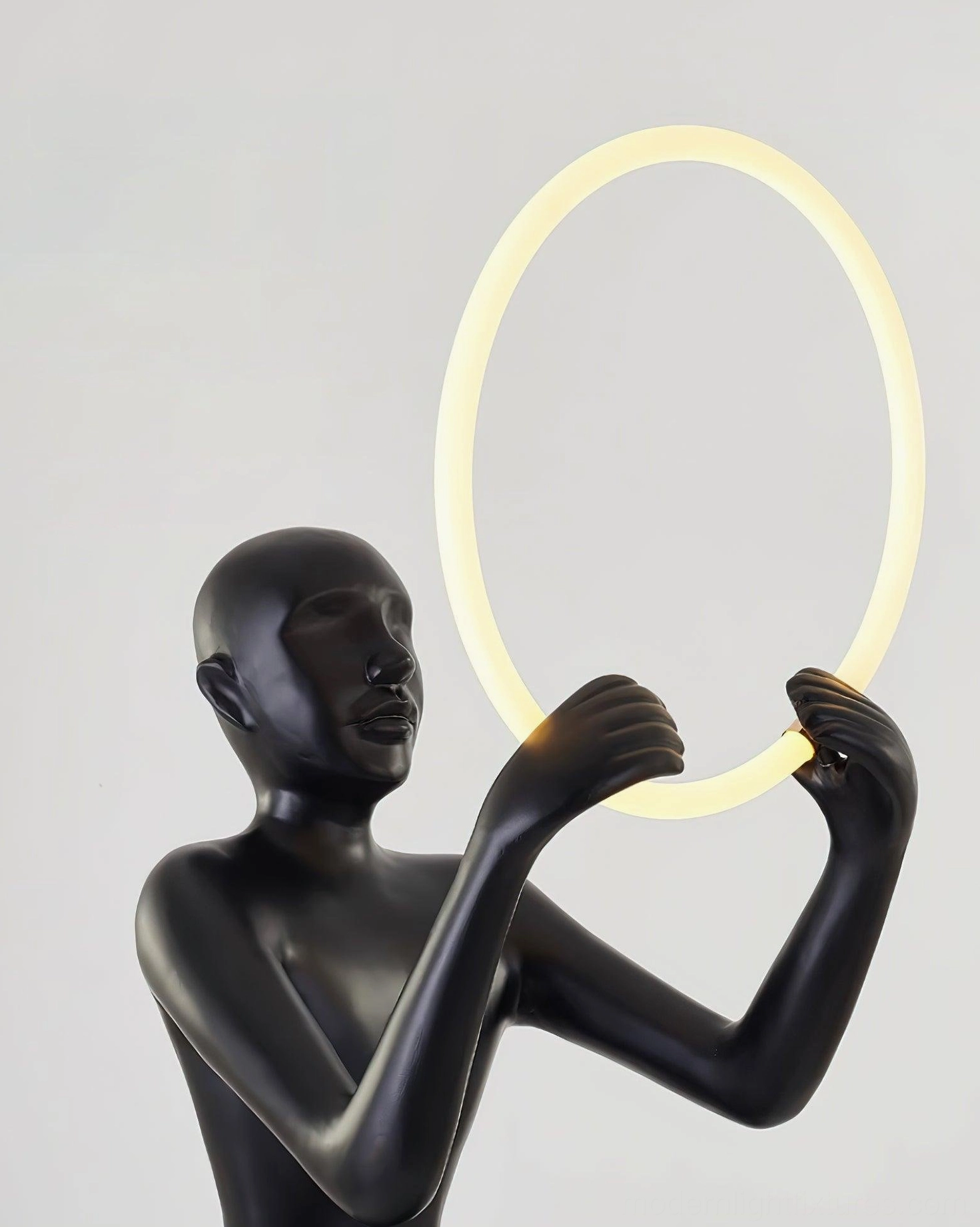 Bella modern sculptural halo floor lamp detail shot showing resin figure and luminous LED crown