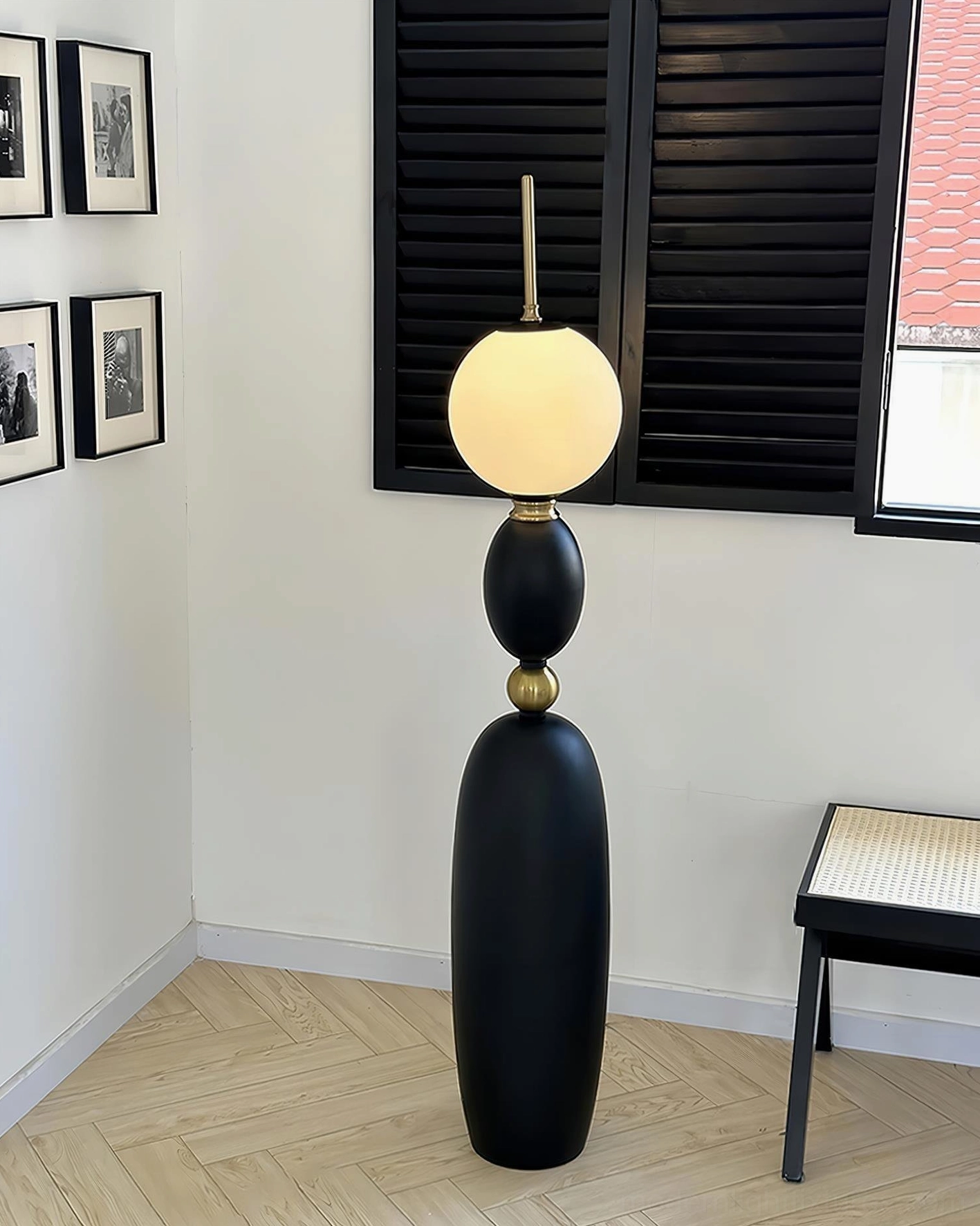 Contemporary matte black Bellamy floor lamp with gold ring detail and wall art display
