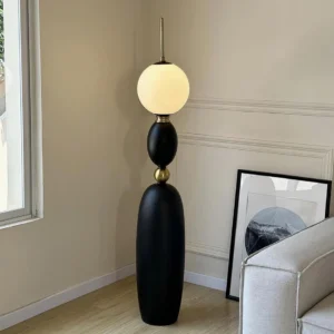 Matte black Bellamy floor lamp in contemporary living room with sofa, mid-century modern style
