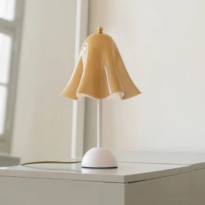 Bellis modern table lamp mustard yellow three-quarter view on white cabinet with natural lighting