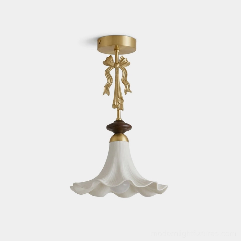 Bellora semi-flush pendant light with pleated white ceramic flower shade, brass bow ornament, and walnut wood accent ring - front studio view