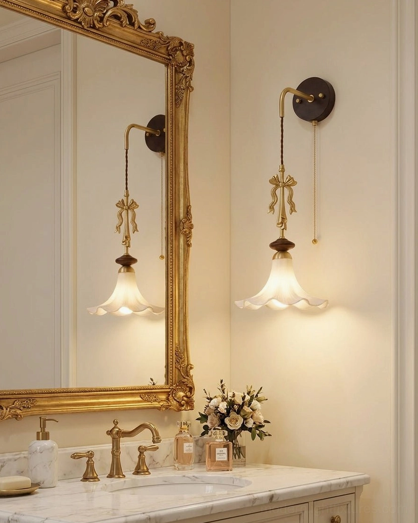 Pair of Bellora wall sconces flanking ornate gilded mirror in French country bathroom vanity
