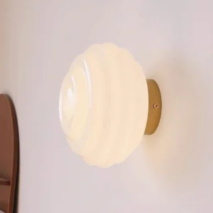 Modern Beverly wall light with gold metal base and warm ambient glow in residential interior