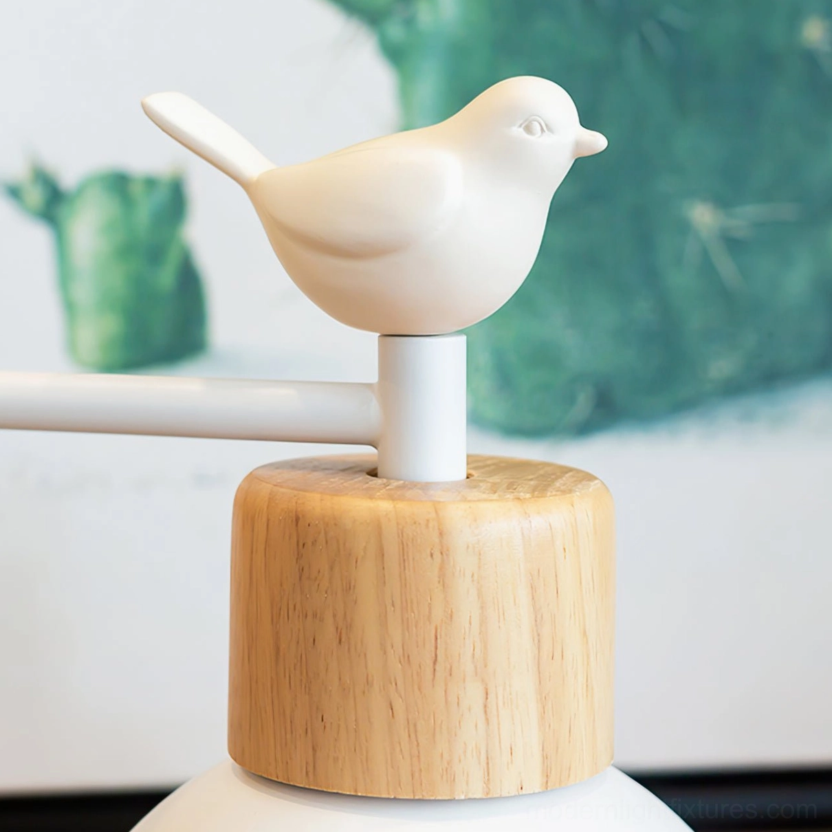 Close-up detail of bird wall sconce top - resin bird accent, wood lamp collar, white metal bracket