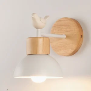 Bird wall sconce side view showing lit warm bulb, natural wood grain texture, and Scandinavian minimalist style