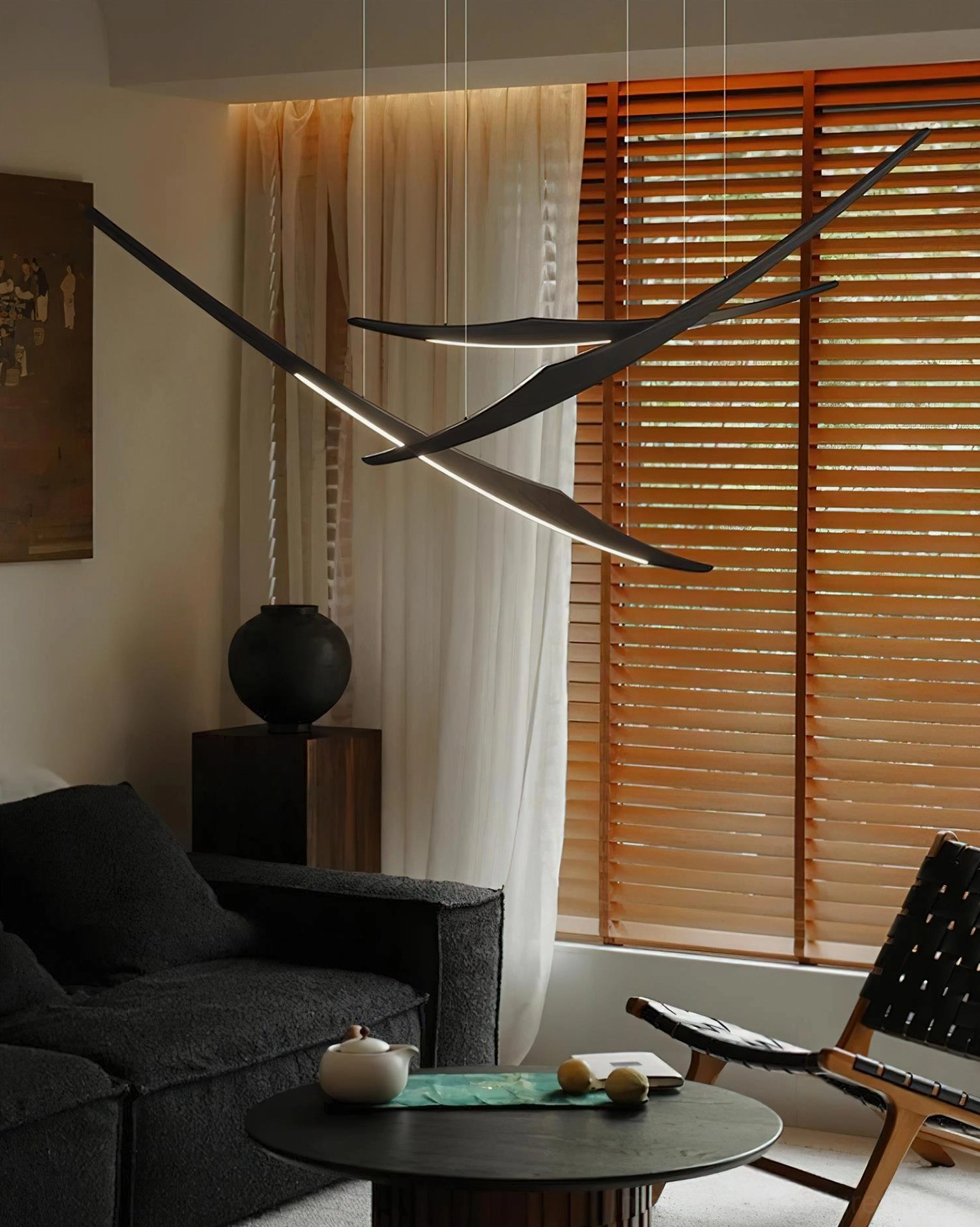Black kinetic arc chandelier demonstrating modern sculptural design in minimalist space