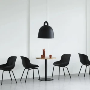 Black bell pendant light suspended in contemporary Nordic dining space with minimalist interior design