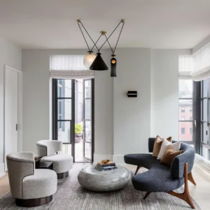 Cluster pendant geometric chandelier in matte black with brass accents above modern living room lounge seating