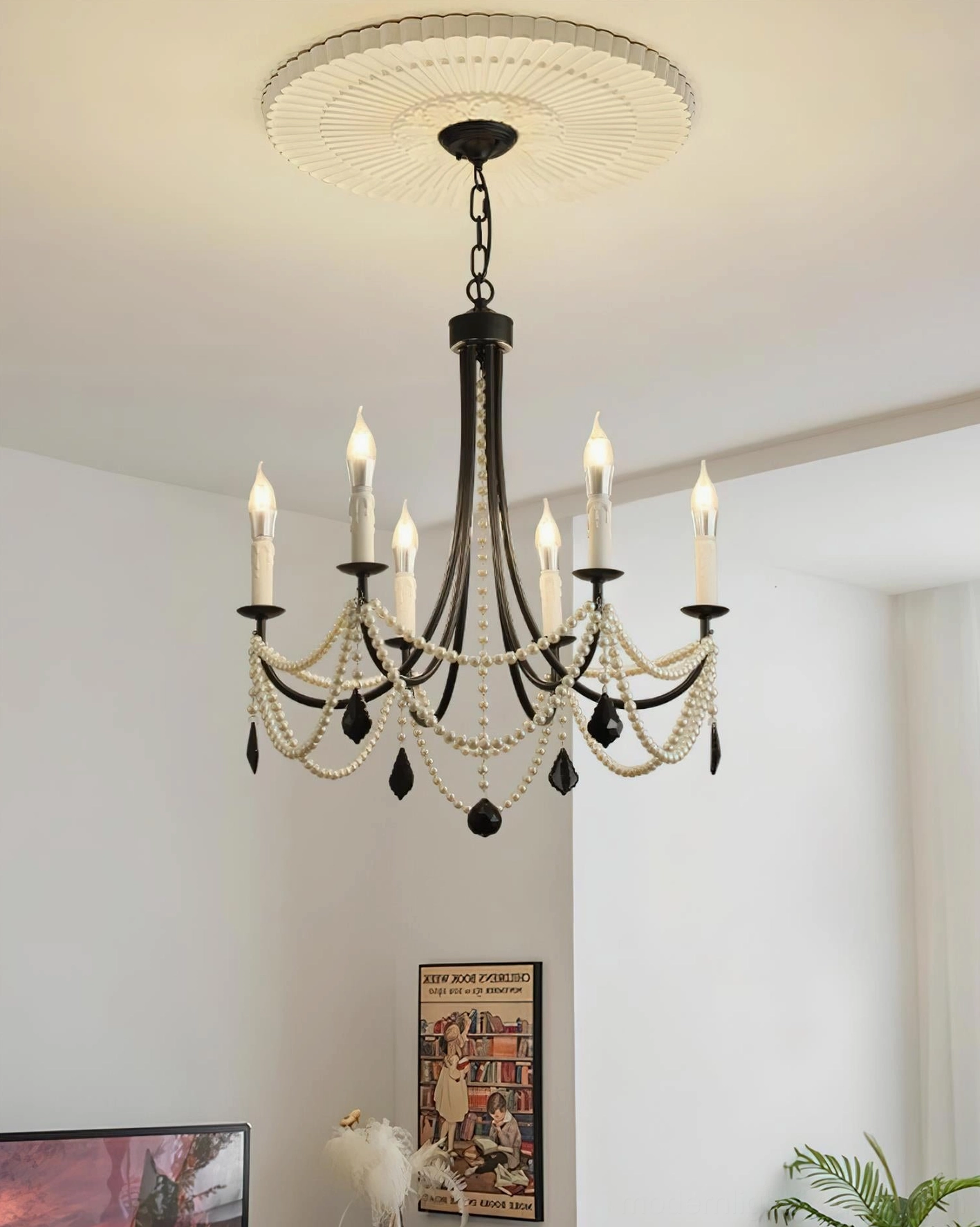 Illuminated black vintage candle chandelier with faux pearl strands and crystal pendants in cozy retro living room