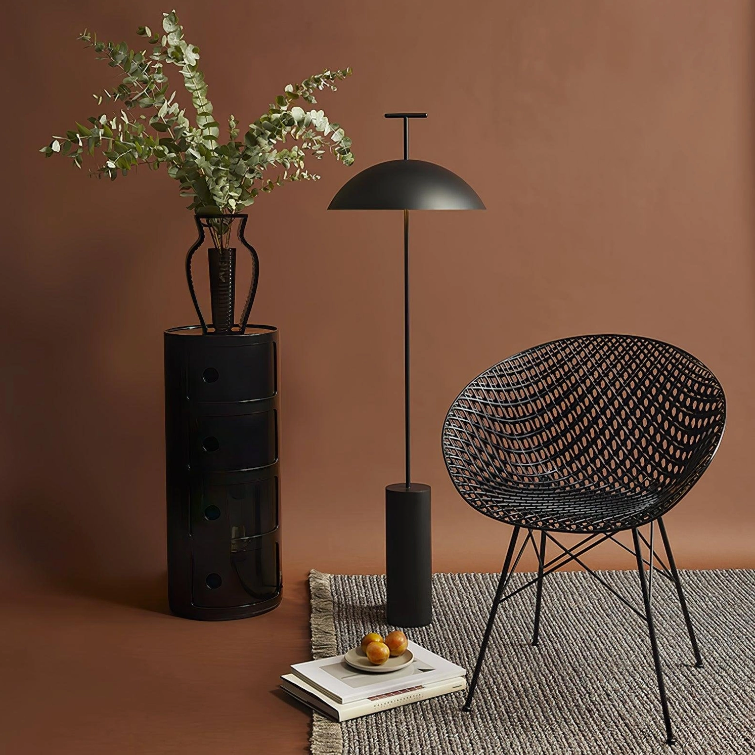 Matte black dome floor lamp three-quarter view in warm terracotta accent corner with woven chair