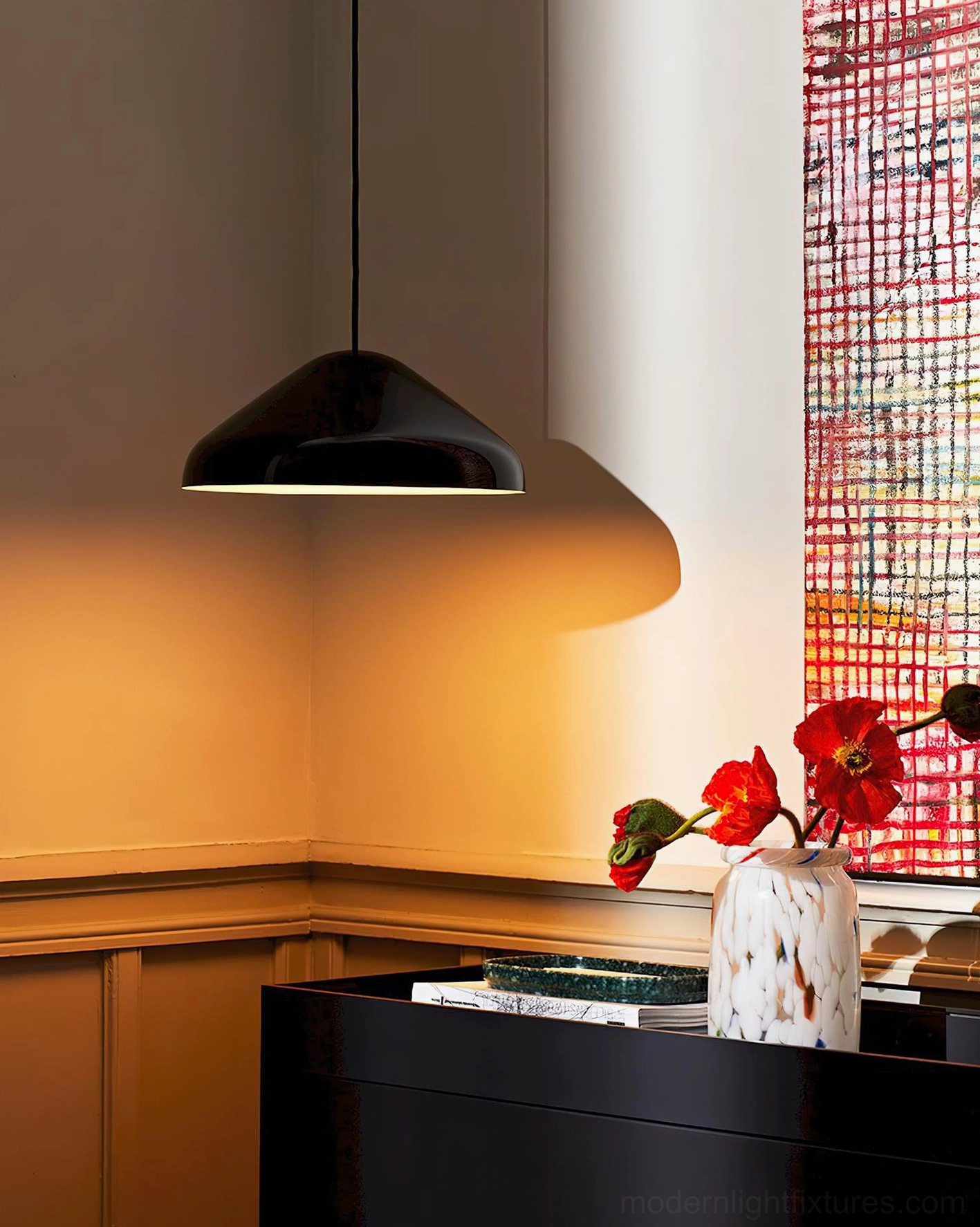 Black glossy dome pendant lamp casting warm ambient light indoors