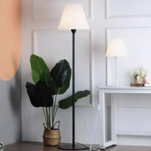 Black metal pole floor lamp with white pleated shade in contemporary home interior three-quarter view