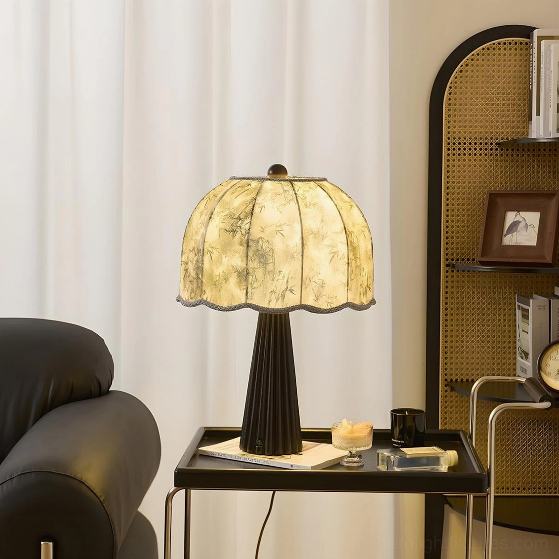 Black fluted table lamp with printed scalloped shade beside leather seating - warm yellow glow