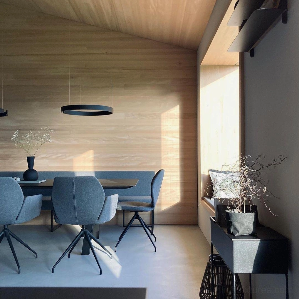 Black halo LED pendant lamp installed in minimalist residential dining room with warm wood wall accents