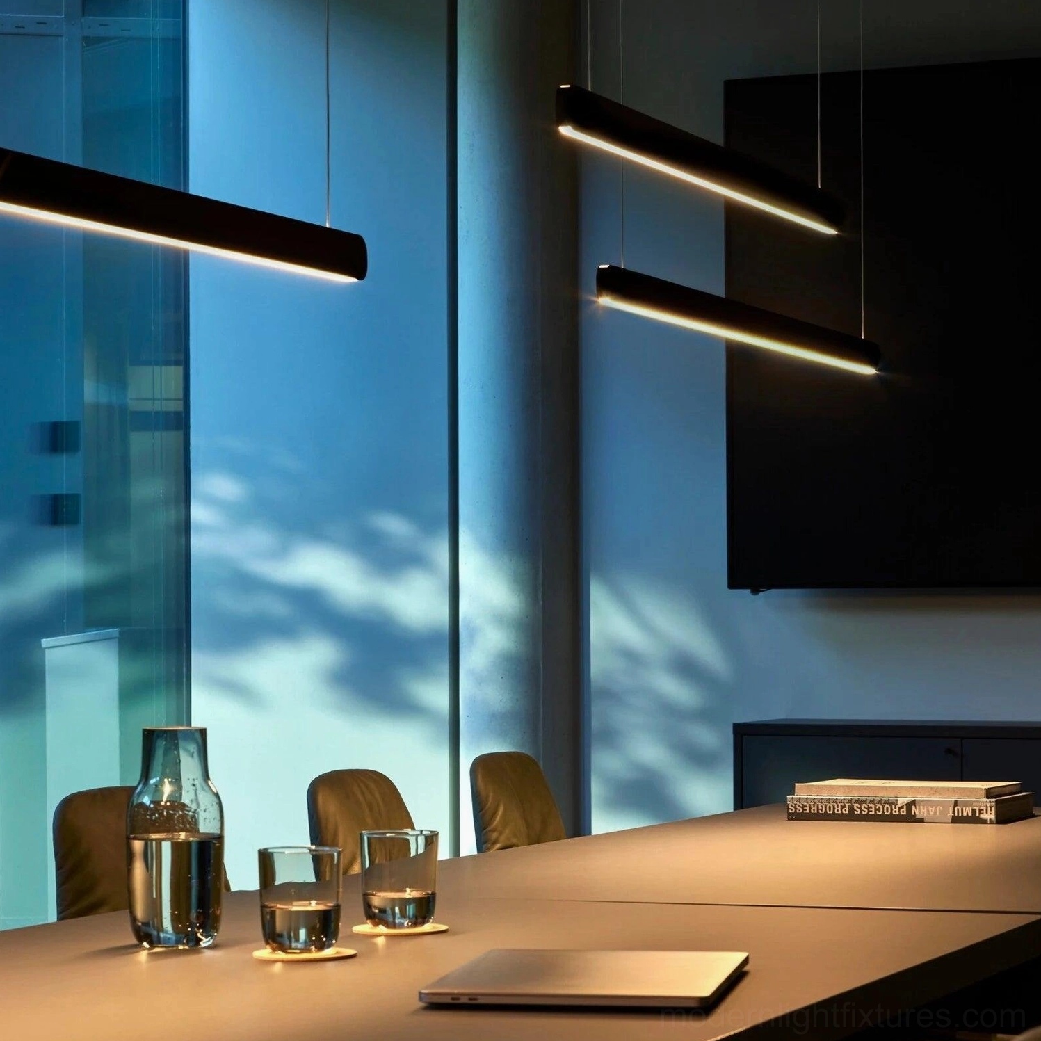 Pair of black linear pendant lights in modern office and dining room setting