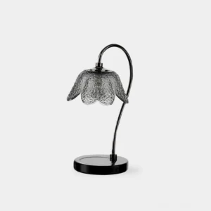 Black marble candle warmer lamp with textured flower glass shade and curved metal arm on white background