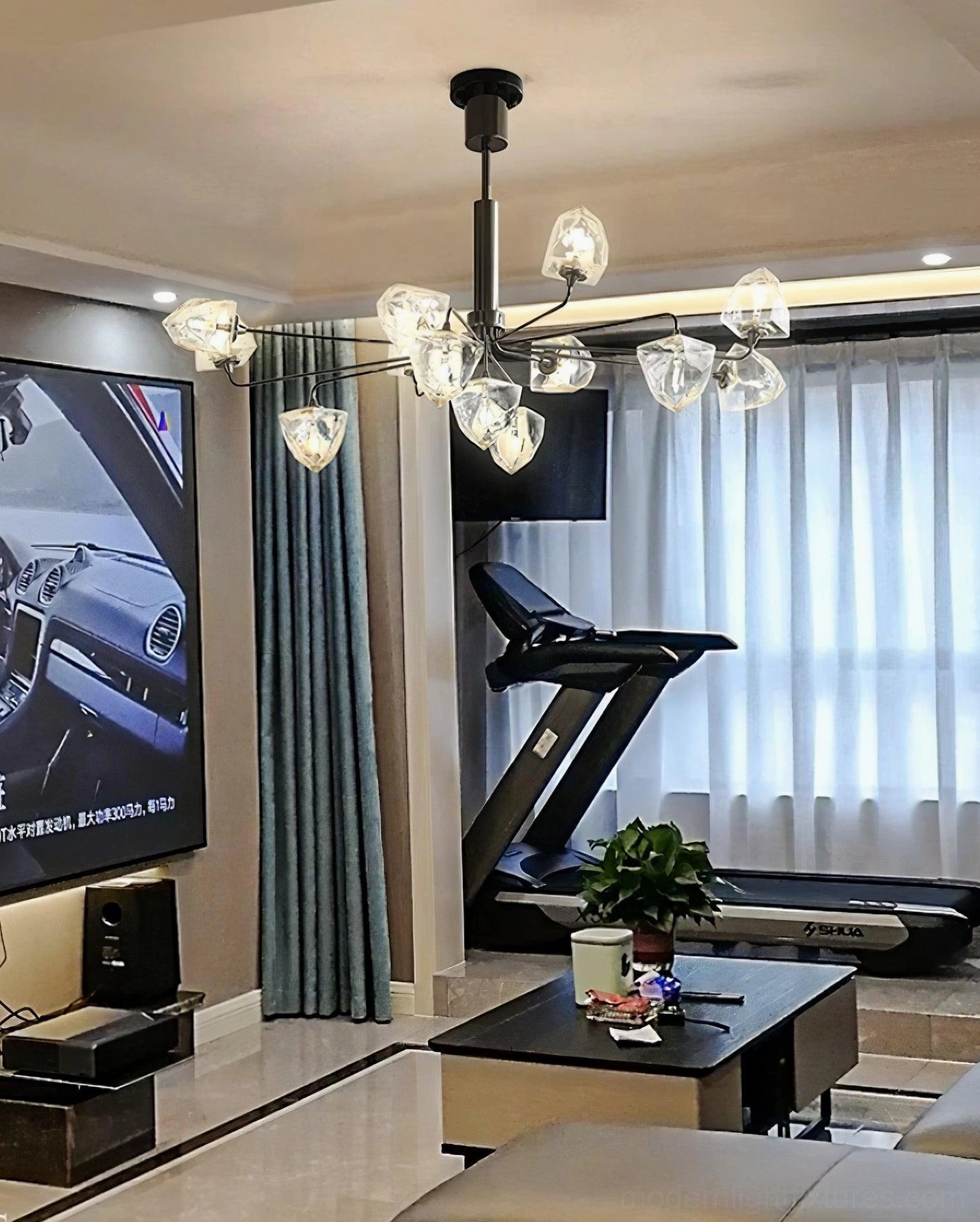Black metal contemporary chandelier with clear faceted glass shades in home gym and theater living room