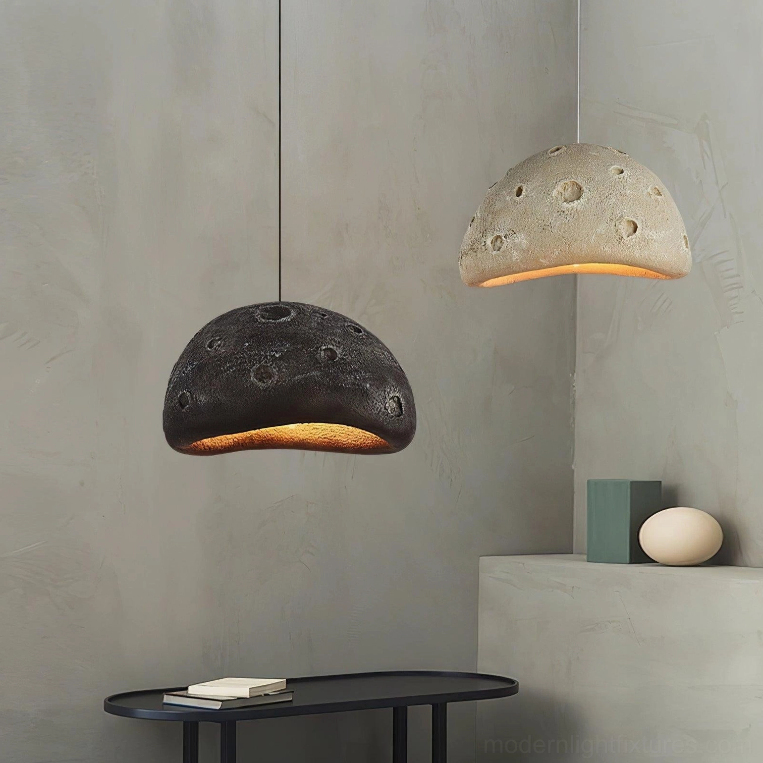 Black meteorite crater pendant light installation showing suspension wire and mounting hardware