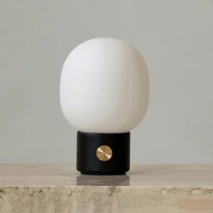 Black Monolith minimalist table lamp displayed on marble countertop with warm ambient light