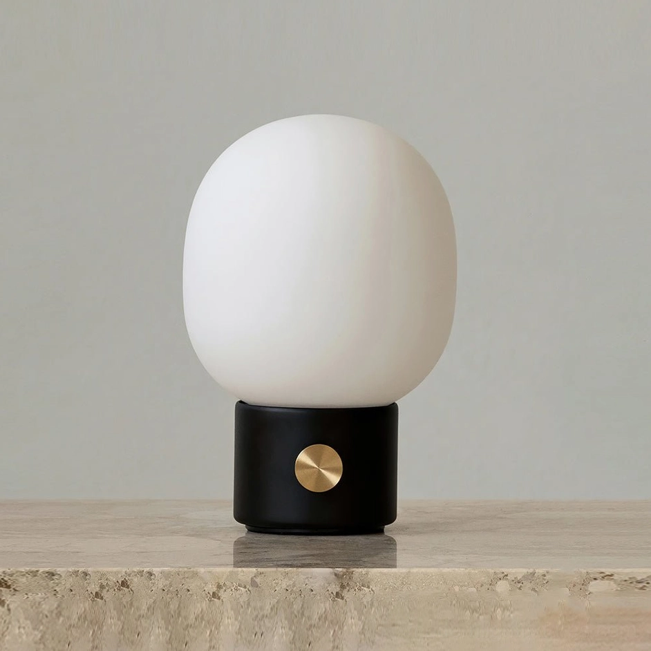 Black Monolith minimalist table lamp displayed on marble countertop with warm ambient light